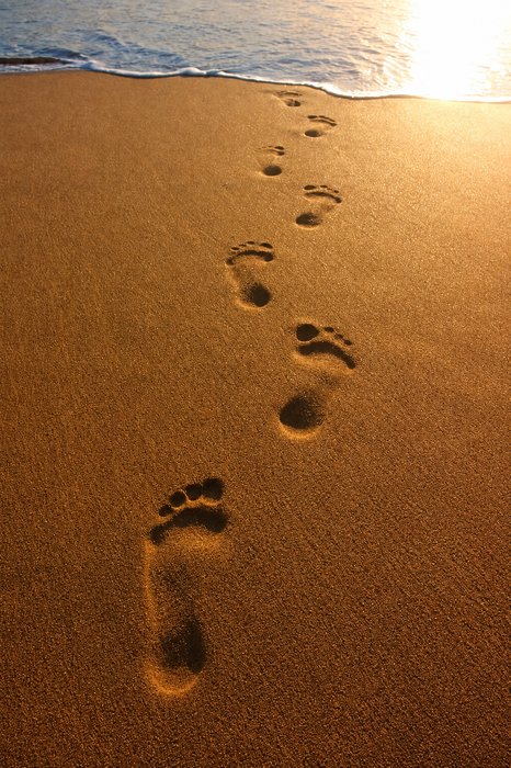 Pegadas na praia com reflexão deslizante